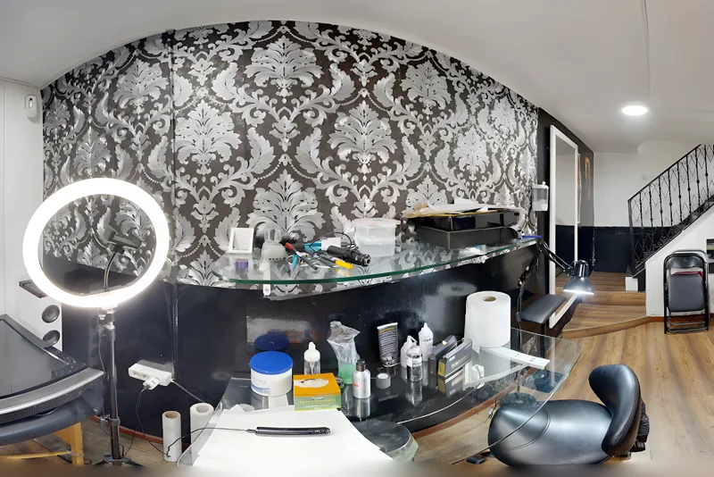 El puesto de tatuar del estudio de Torremolinos: pared de damasco, aro de luz y mostrador de cristal