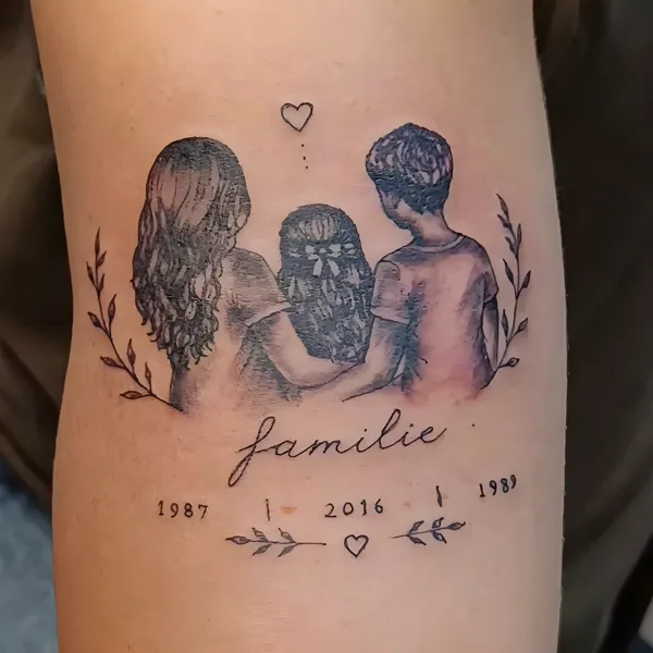 Una familia de espaldas, en negro y gris, con la palabra familie y tres fechas, en el brazo