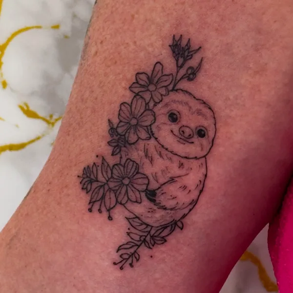 Perezoso entre flores, en línea fina, en el brazo